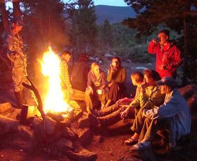 Компания туристов сидит у костра.